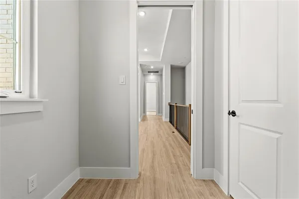 a view of a hallway with wooden floor