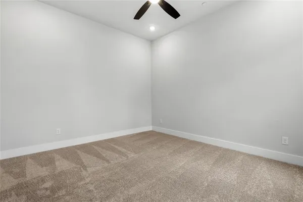 an empty room with ceiling fan and window