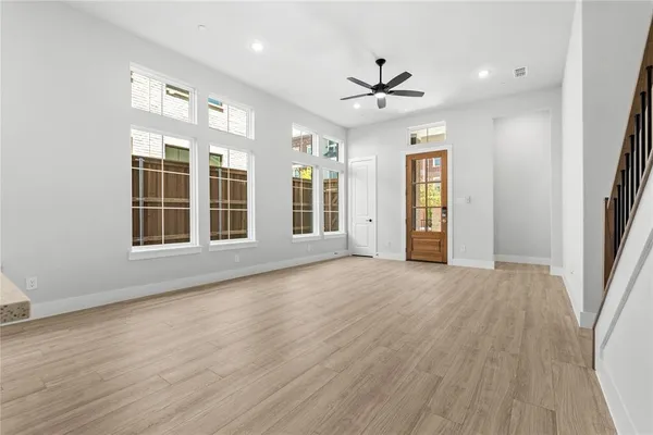 a view of an empty room with a window and wooden floor
