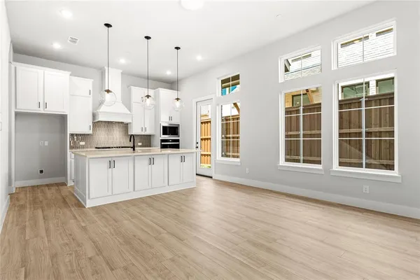 a large kitchen with stainless steel appliances granite countertop a large window a oven a sink and a refrigerator