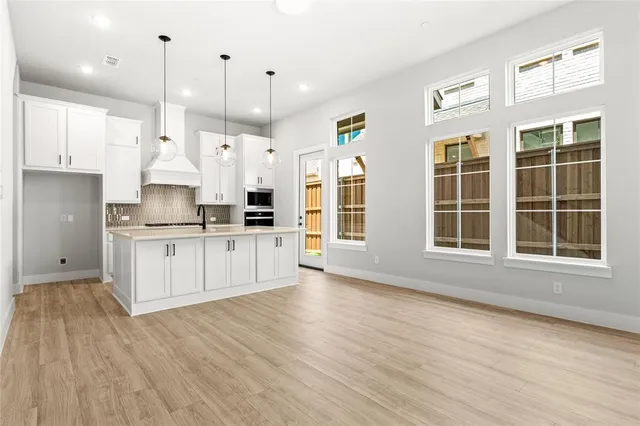 a large kitchen with stainless steel appliances granite countertop a large window a oven a sink and a refrigerator