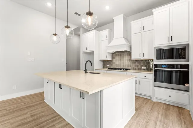 a kitchen with stainless steel appliances a stove a sink and a refrigerator