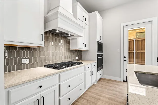 a kitchen with stainless steel appliances a stove a sink and a microwave