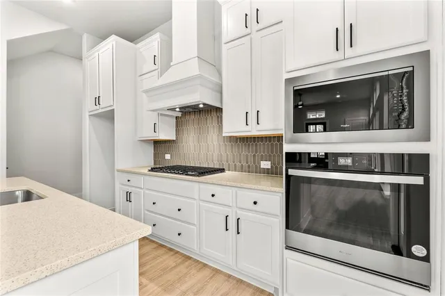 a kitchen with stainless steel appliances white cabinets and white appliances