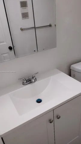 a white toilet sitting next to a bathroom sink