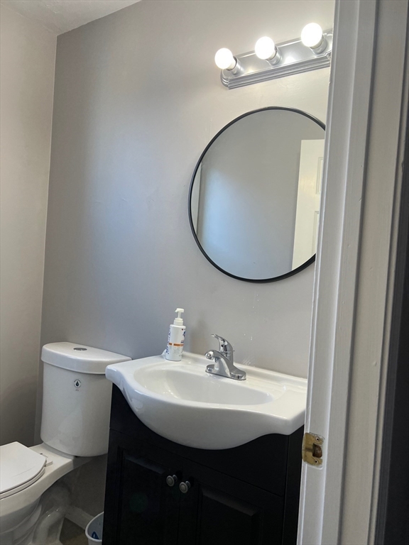 a bathroom with a sink toilet and mirror