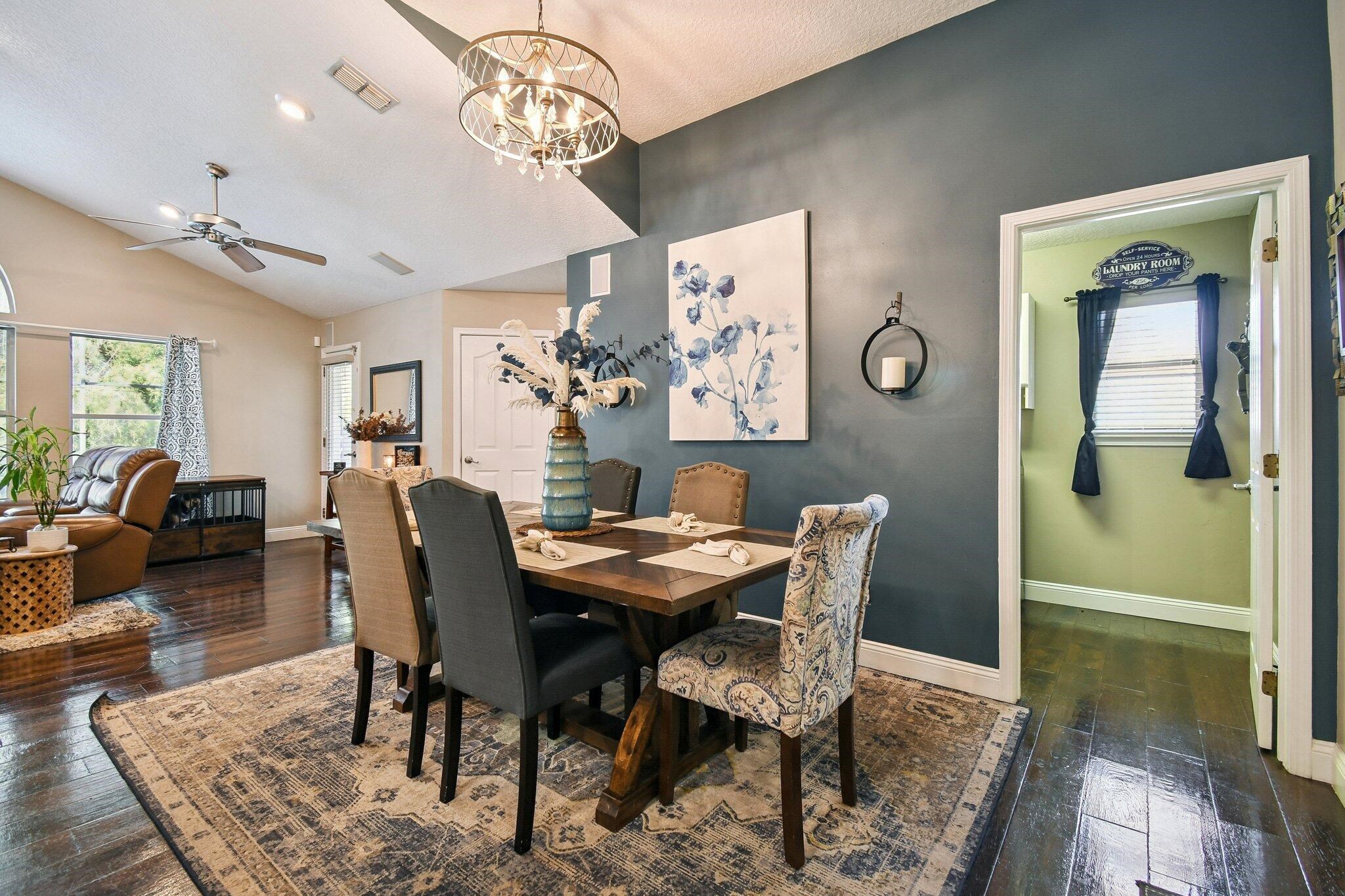 1220 Creek Bend Road Jacksonville, FL 32259 - Photo 11 of 30 Dining space featuring ceiling fan, healthy amount of natural light, dark wood-type flooring, a chandelier, and vaulted ceiling