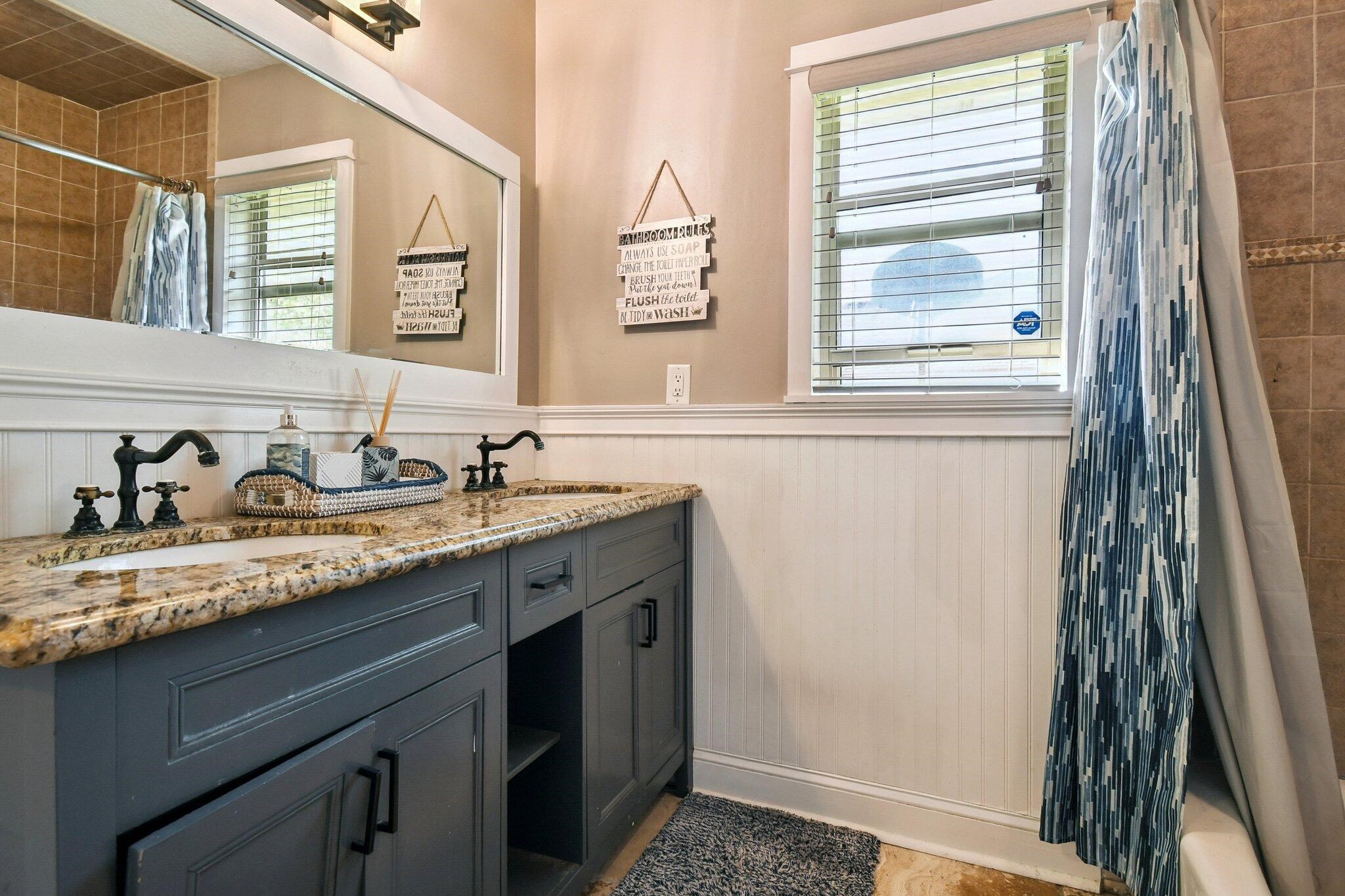 1220 Creek Bend Road Jacksonville, FL 32259 - Photo 18 of 30 Full bath with double vanity, a wainscoted wall, and tiled shower / bath combo