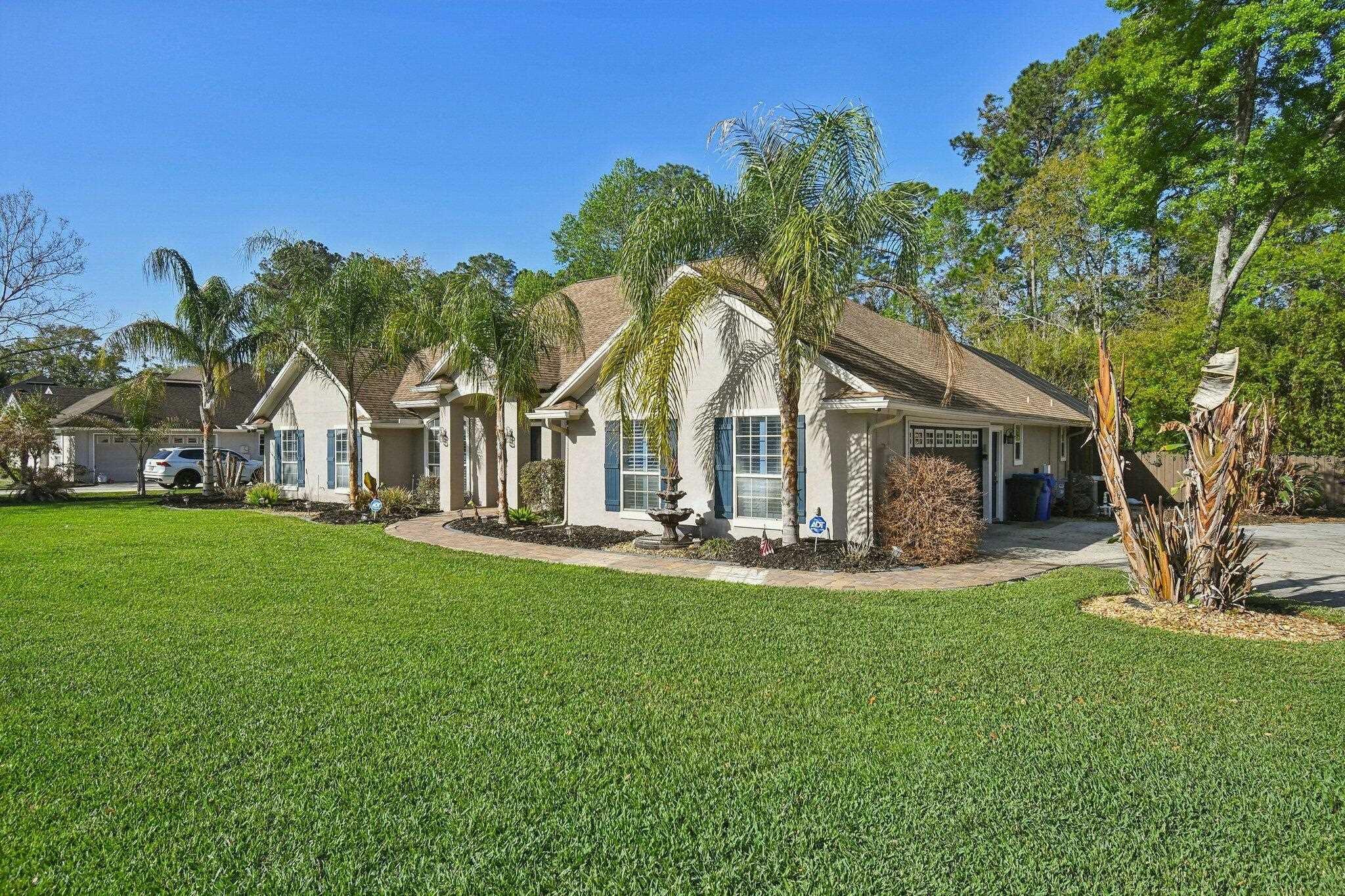 1220 Creek Bend Road Jacksonville, FL 32259 - Photo 2 of 30 View of front facade with a front yard, an attached garage, stucco siding, and driveway