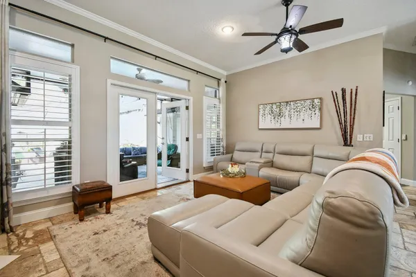 a living room with furniture a clock and a ceiling fan