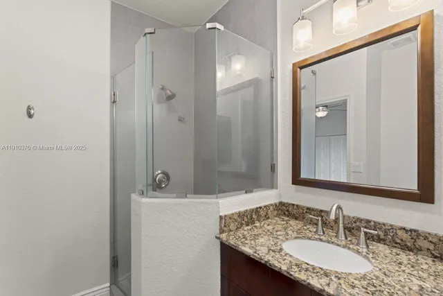 a view of an empty room with wooden floor and a ceiling fan