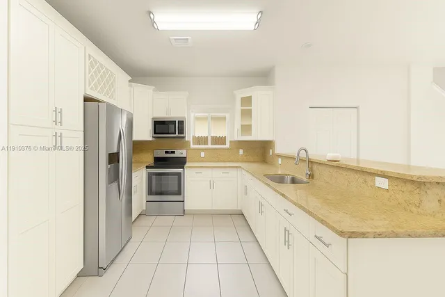 an empty room with chandelier fan and windows