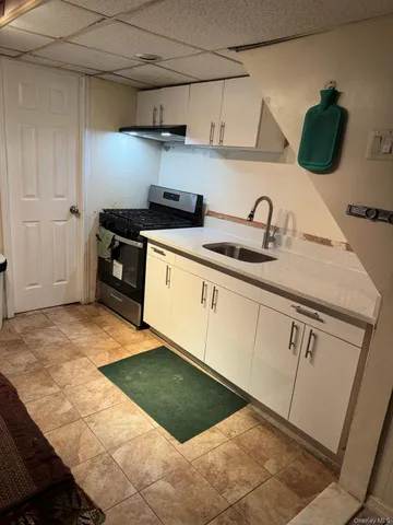 a kitchen with granite countertop a sink a stove and cabinets