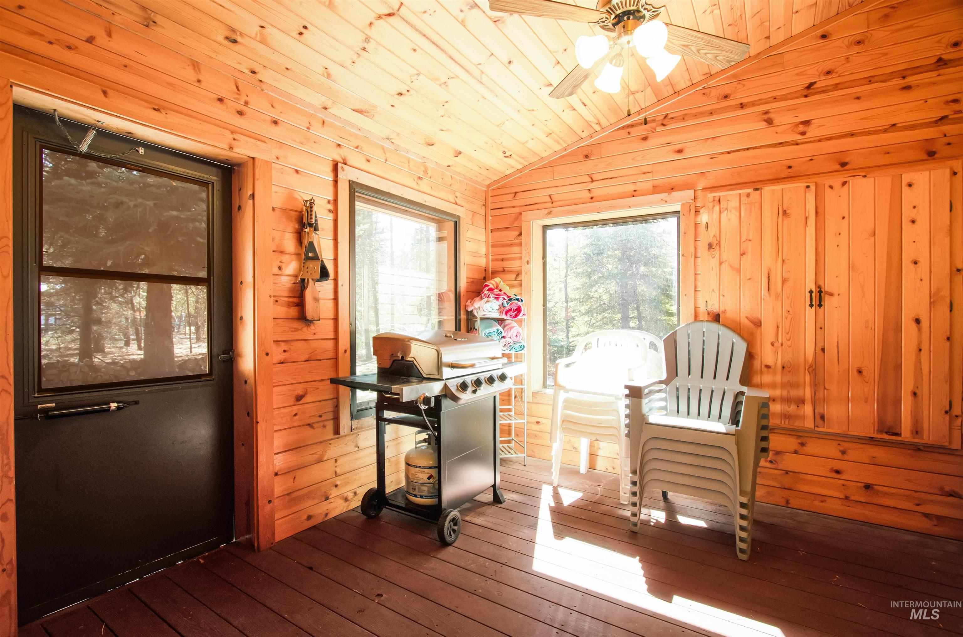 12712 Hereford Road Donnelly, ID 83615 - Photo 19 of 50 Dining room featuring a ceiling fan, hardwood / wood-style flooring, a vaulted wood ceiling, and wood walls