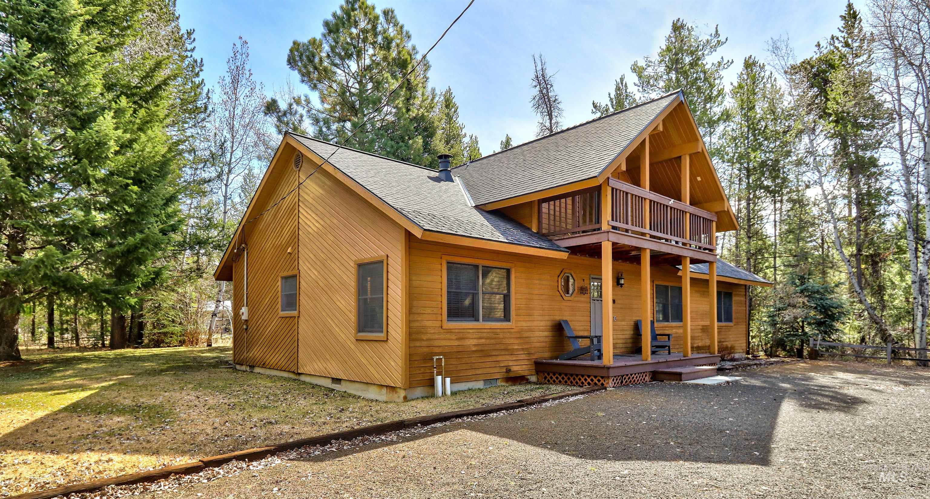 12712 Hereford Road Donnelly, ID 83615 - Photo 3 of 50 Rear view of house featuring a shingled roof, a yard, and a balcony