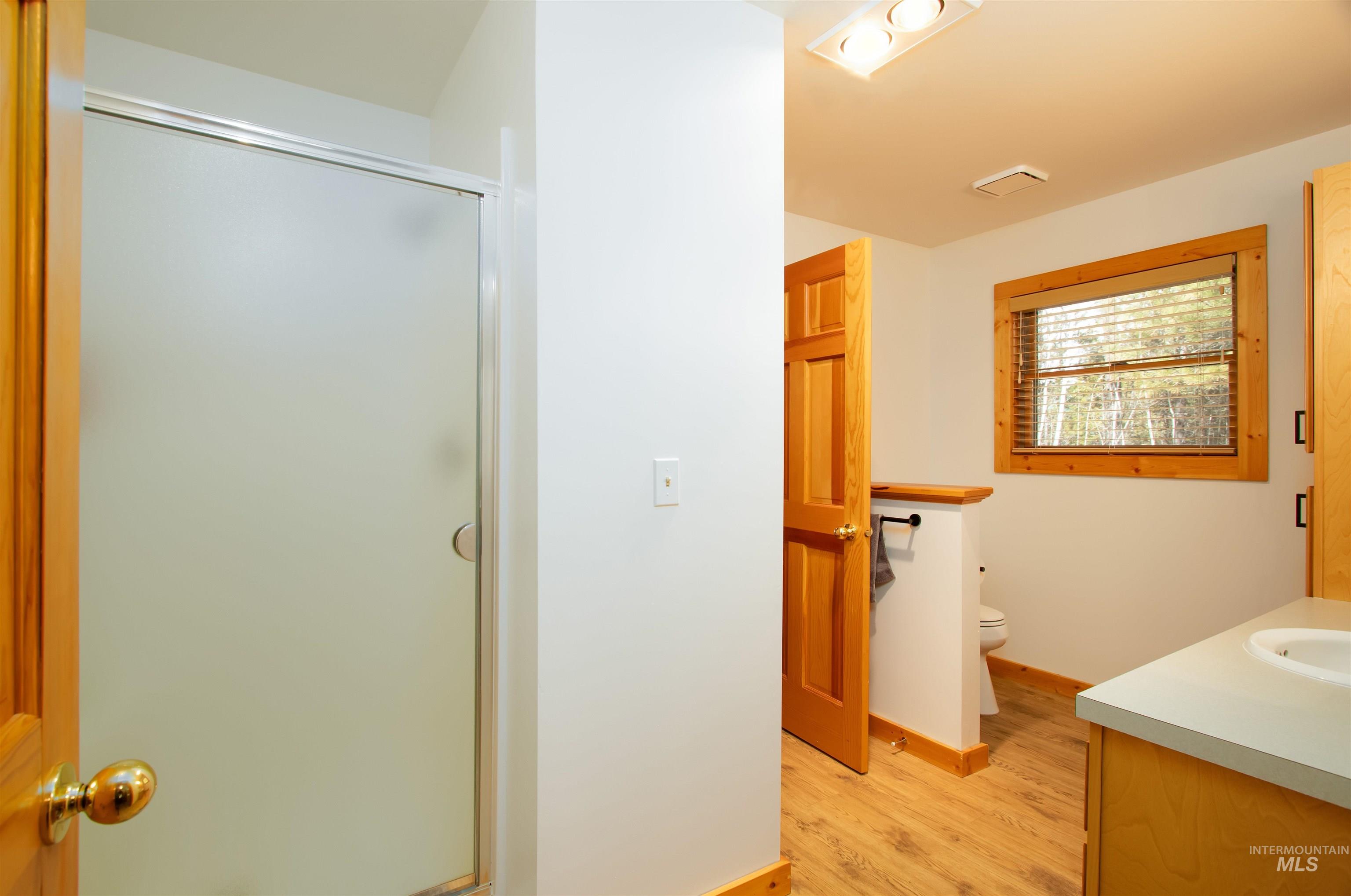 12712 Hereford Road Donnelly, ID 83615 - Photo 36 of 50 Full bathroom featuring vanity, a stall shower, and light wood-style floors