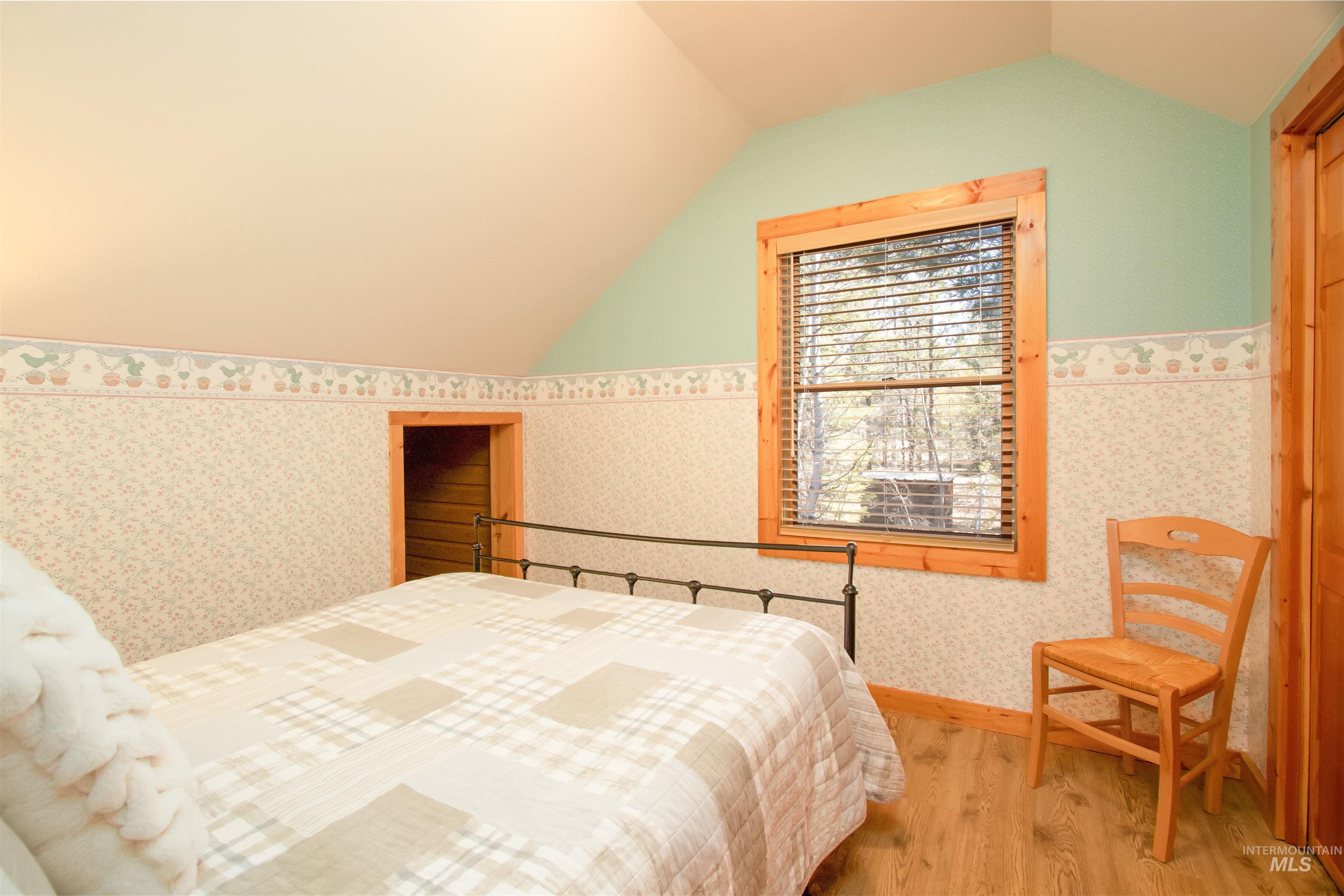12712 Hereford Road Donnelly, ID 83615 - Photo 41 of 50 Bedroom featuring wood finished floors and wallpapered walls