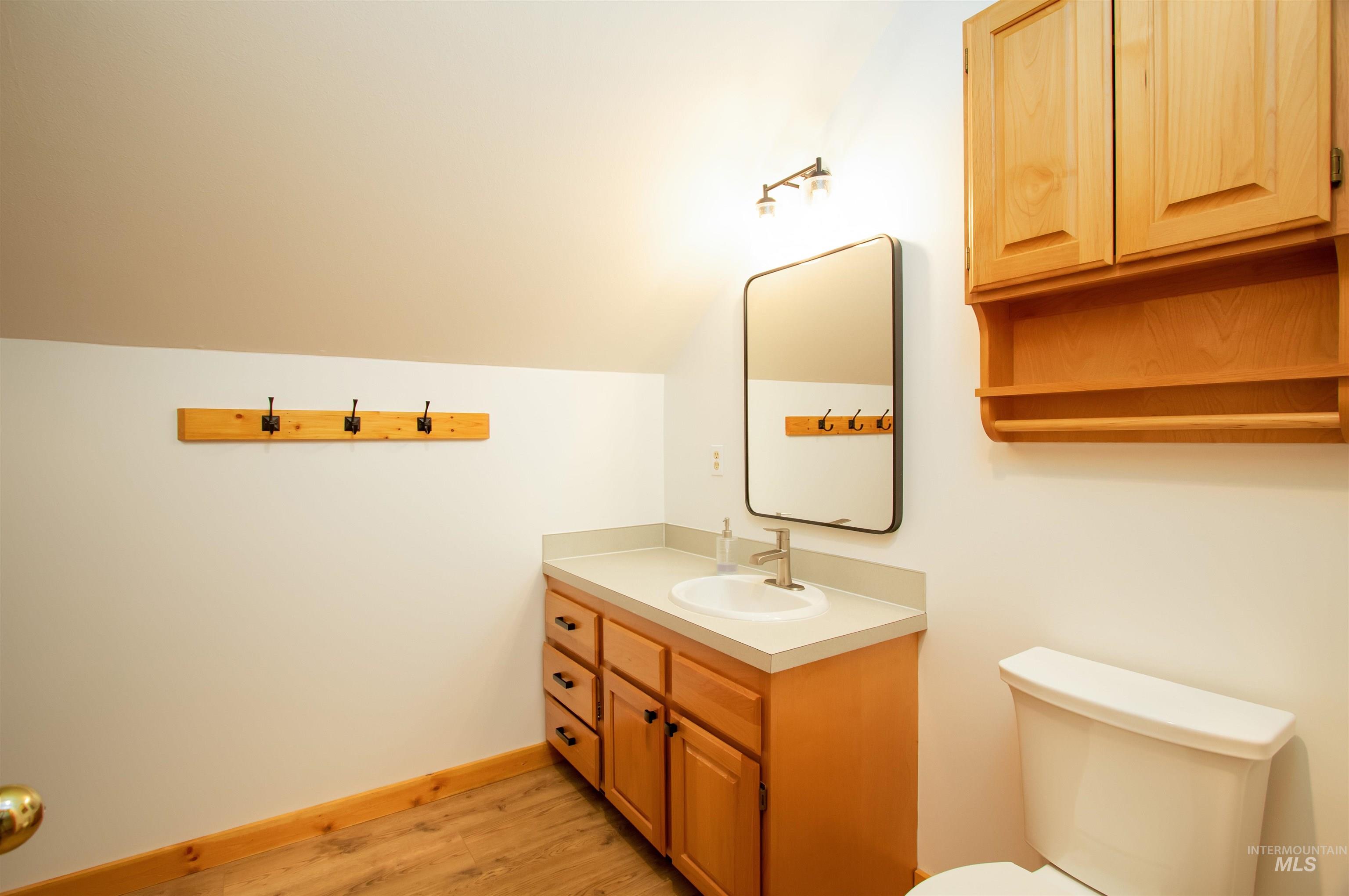 12712 Hereford Road Donnelly, ID 83615 - Photo 42 of 50 Half bathroom with vanity, vaulted ceiling, and light wood-style floors