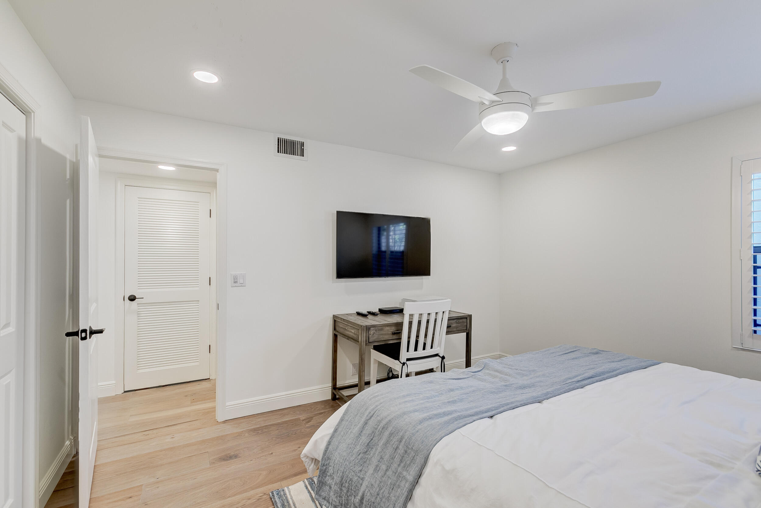 16622 Traders Crossing North, Unit 102 Jupiter, FL 33477 - Photo 15 of 19 a bedroom with a bed and a flat screen tv
