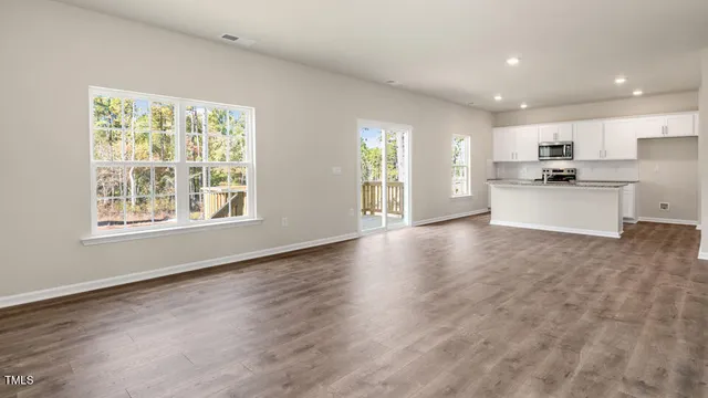 a large kitchen with stainless steel appliances granite countertop a large counter top and a wooden floors