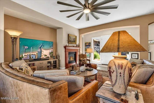 a living room with furniture a large window and a chandelier