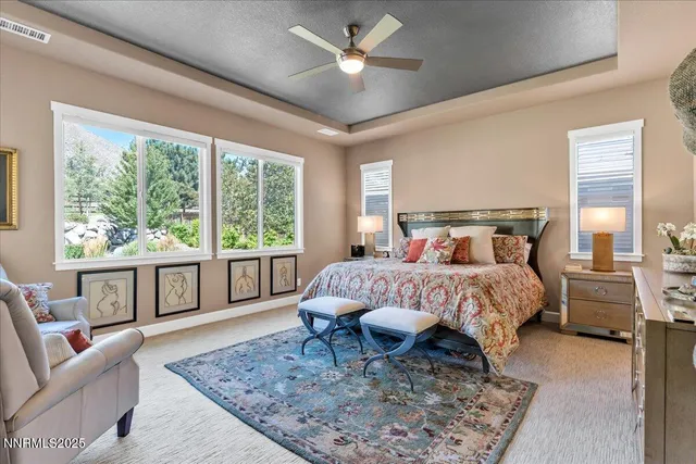 a bed sitting in a bedroom next to a window with a rug and wooden floor