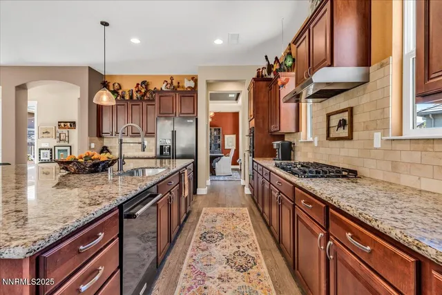 a large kitchen with stainless steel appliances granite countertop a stove and a sink