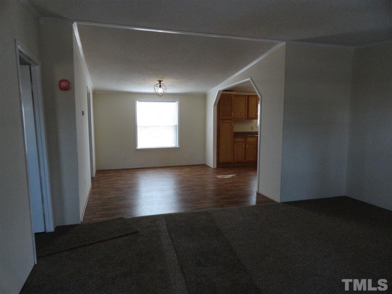 3388 Dirgie Mine Road Roxboro, NC 27574 - Photo 3 of 12 an empty room with wooden floor and windows
