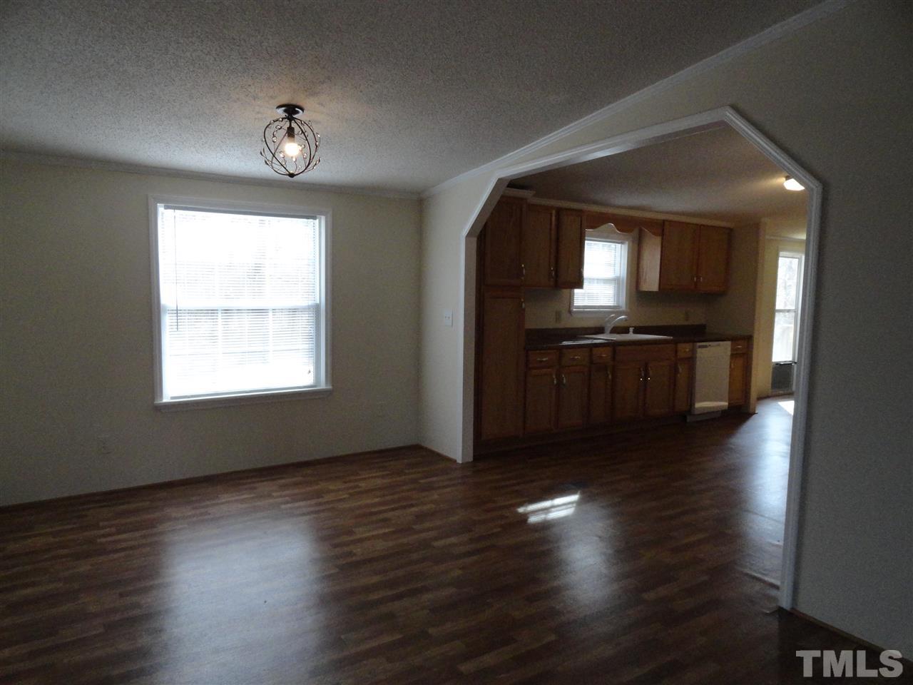 3388 Dirgie Mine Road Roxboro, NC 27574 - Photo 4 of 12 an empty room with wooden floor and windows