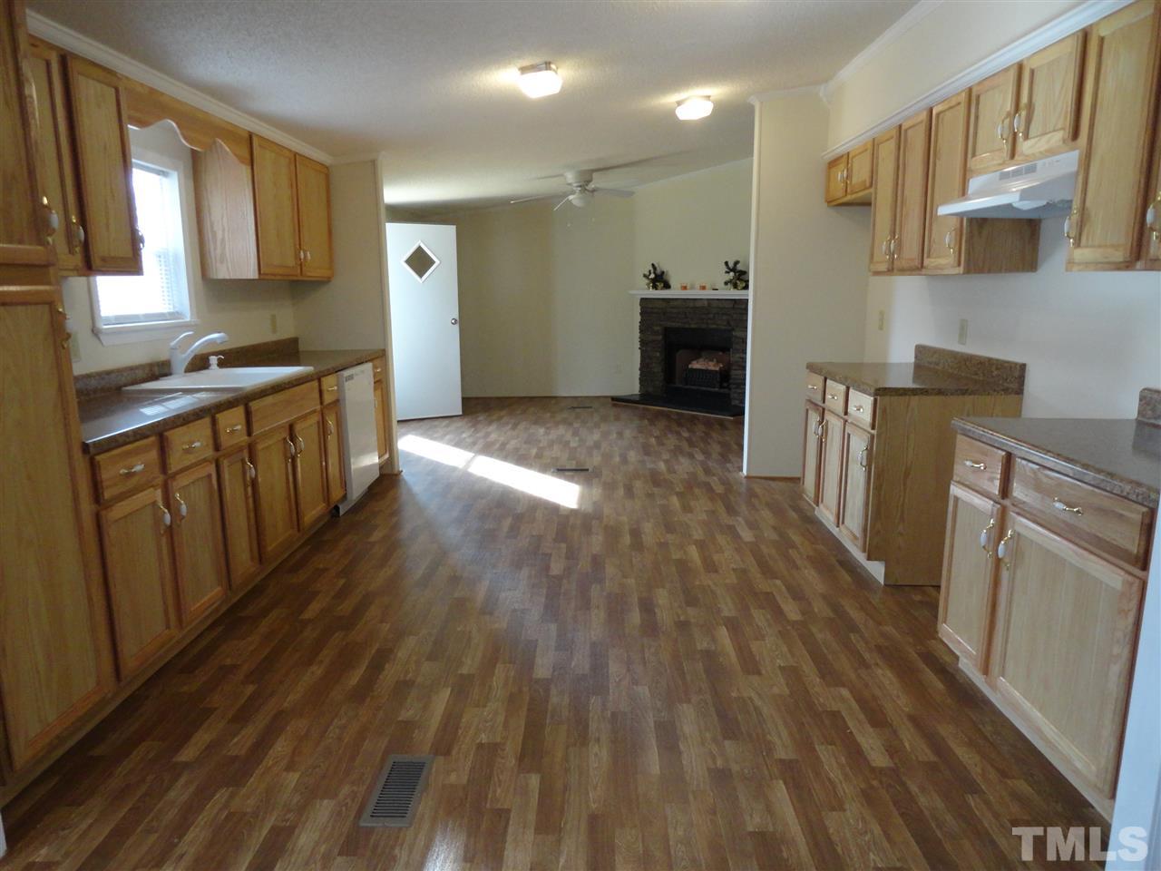 3388 Dirgie Mine Road Roxboro, NC 27574 - Photo 7 of 12 a kitchen with granite countertop a stove top oven a sink dishwasher and a refrigerator with wooden floor
