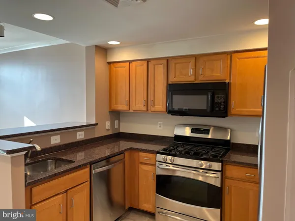a kitchen with stainless steel appliances a stove microwave and sink