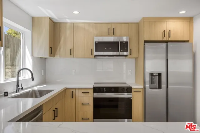 a kitchen with stainless steel appliances wooden cabinets a sink and a stove
