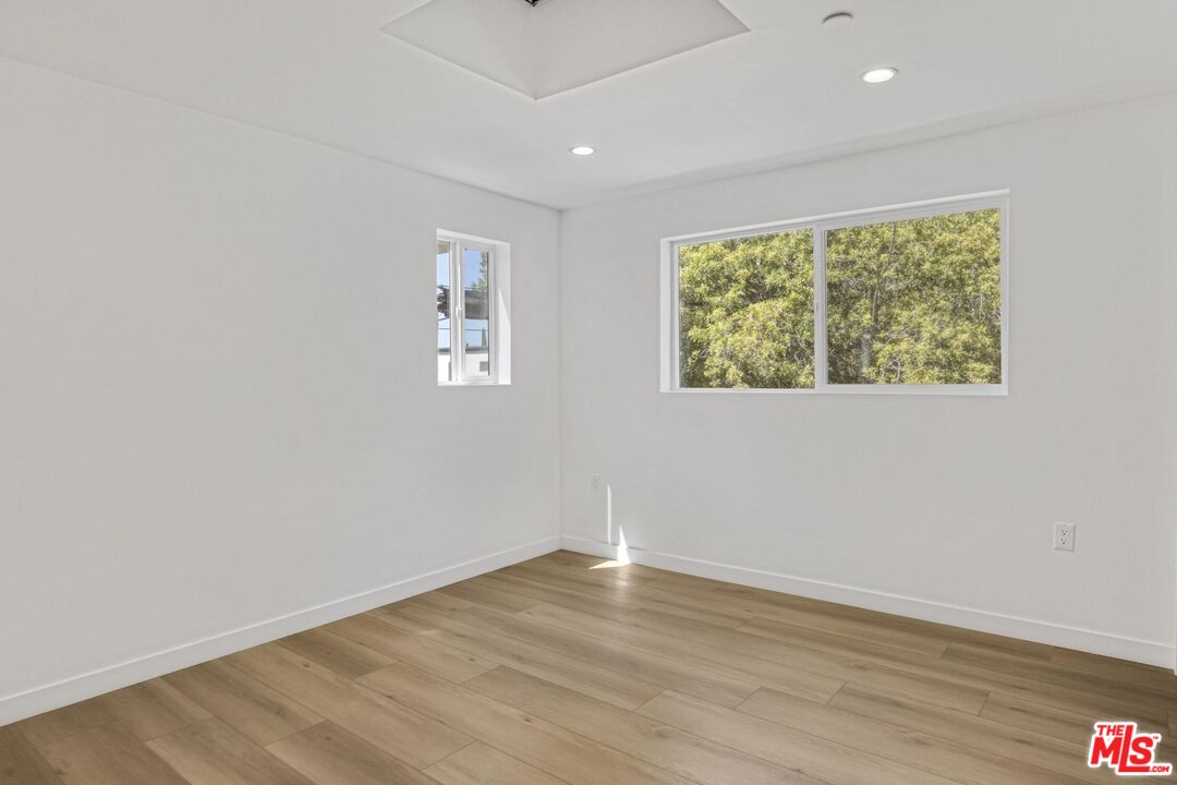 10826 3/4 Hesby Street North Hollywood, CA 91601 - Photo 14 of 26 an empty room with wooden floor and windows