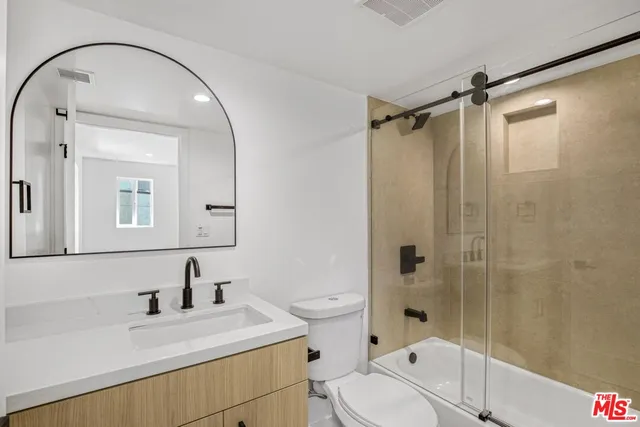 a bathroom with a sink toilet vanity and shower