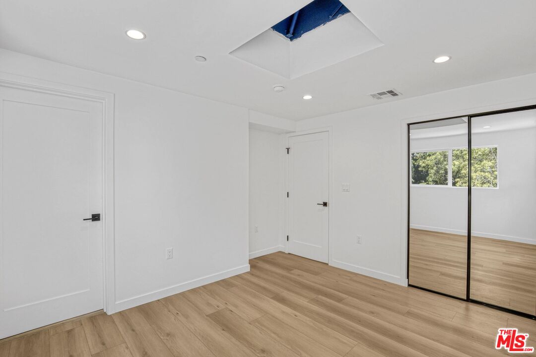 10826 3/4 Hesby Street North Hollywood, CA 91601 - Photo 16 of 26 an empty room with wooden floor and windows