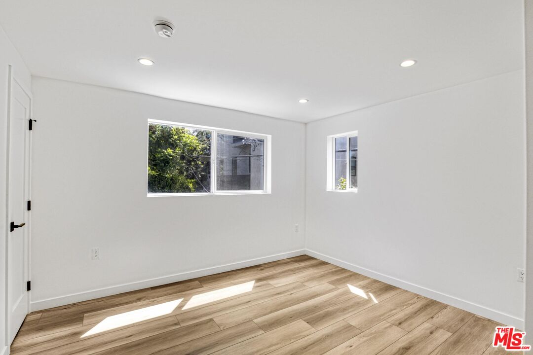 10826 3/4 Hesby Street North Hollywood, CA 91601 - Photo 17 of 26 a view of empty room with wooden floor and fan