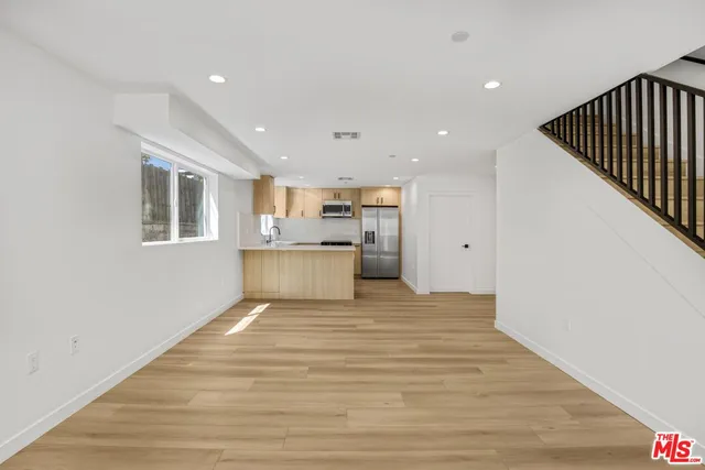 a view of a kitchen with a sink and wooden floor
