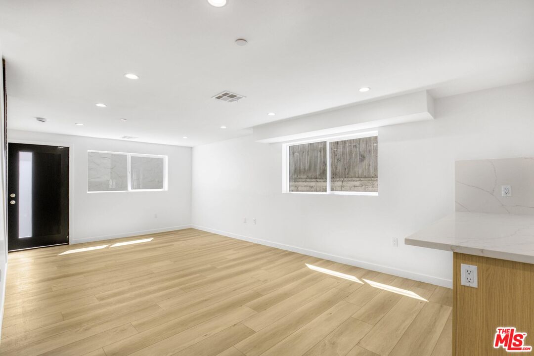 10826 3/4 Hesby Street North Hollywood, CA 91601 - Photo 9 of 26 a view of an empty room with wooden floor and a window