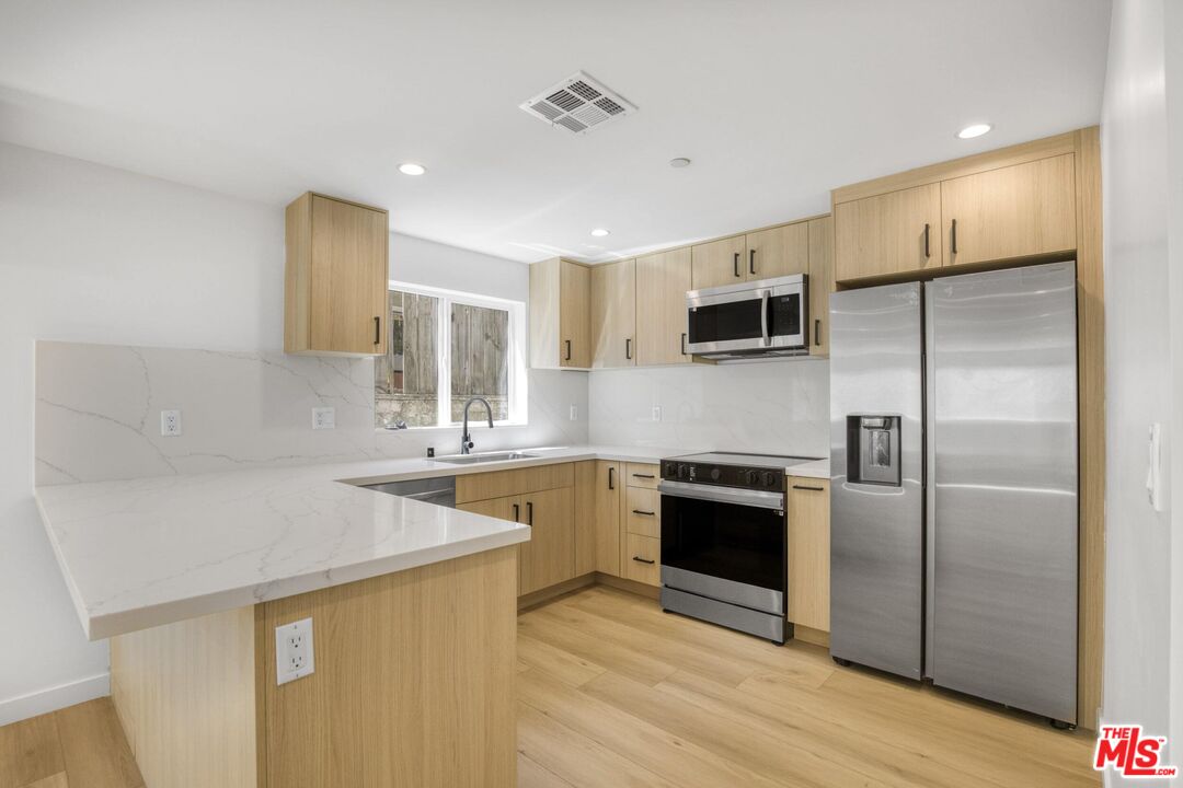 10826 3/4 Hesby Street North Hollywood, CA 91601 - Photo 10 of 26 a kitchen with a sink stove and refrigerator
