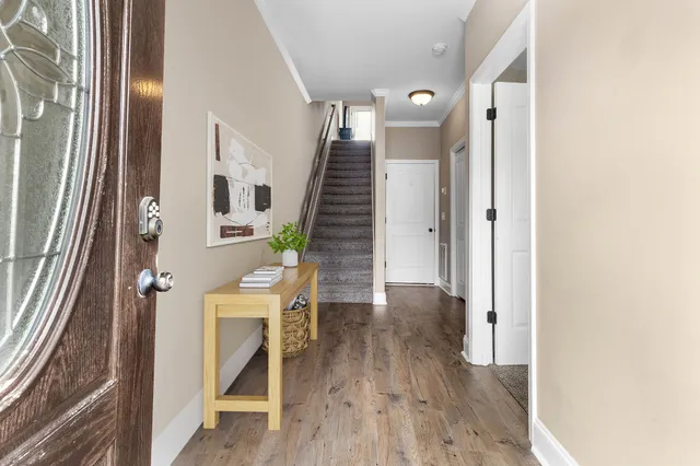 a view of a hallway with wooden floor and staircase