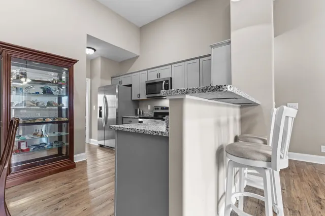 a kitchen with stainless steel appliances granite countertop a refrigerator and a stove top oven