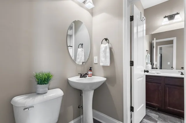 a bathroom with a sink toilet and a mirror