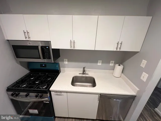 a kitchen with a sink a stove and cabinets