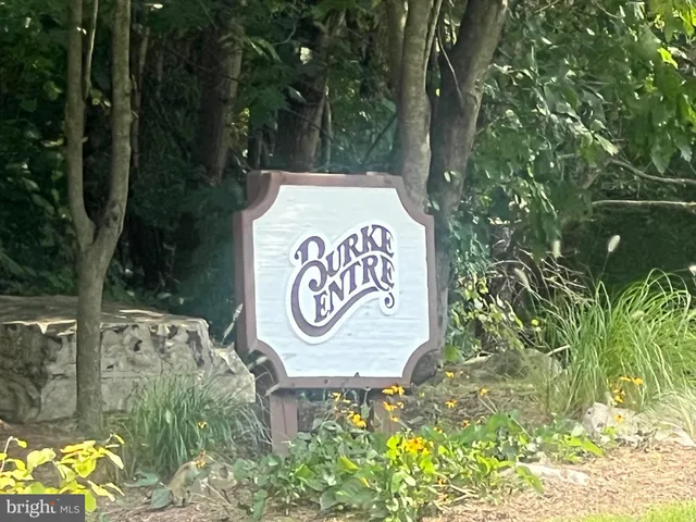 a sign that is on a brick wall with a small yard