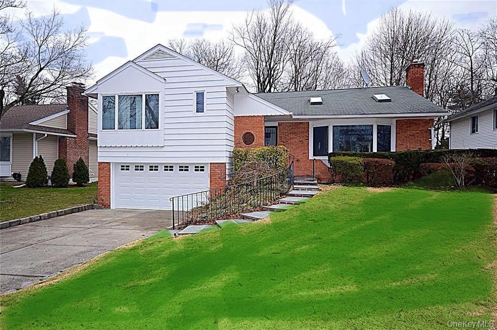 a front view of a house with a garden and yard
