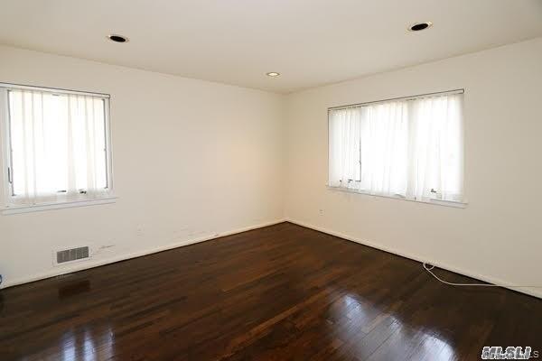 5 Gilbert Road Great Neck, NY 11024 - Photo 14 of 20 a view of an empty room with wooden floor and a window