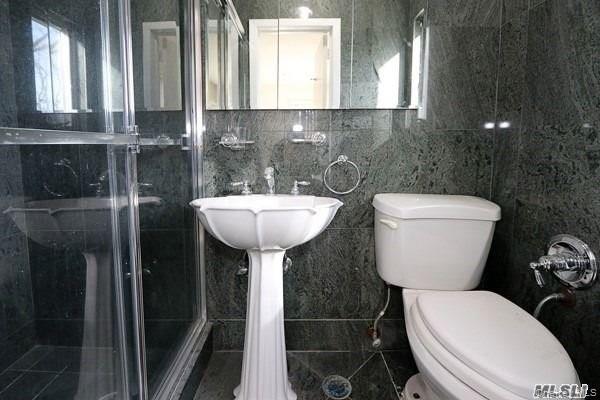 5 Gilbert Road Great Neck, NY 11024 - Photo 15 of 20 a bathroom with a toilet sink and mirror