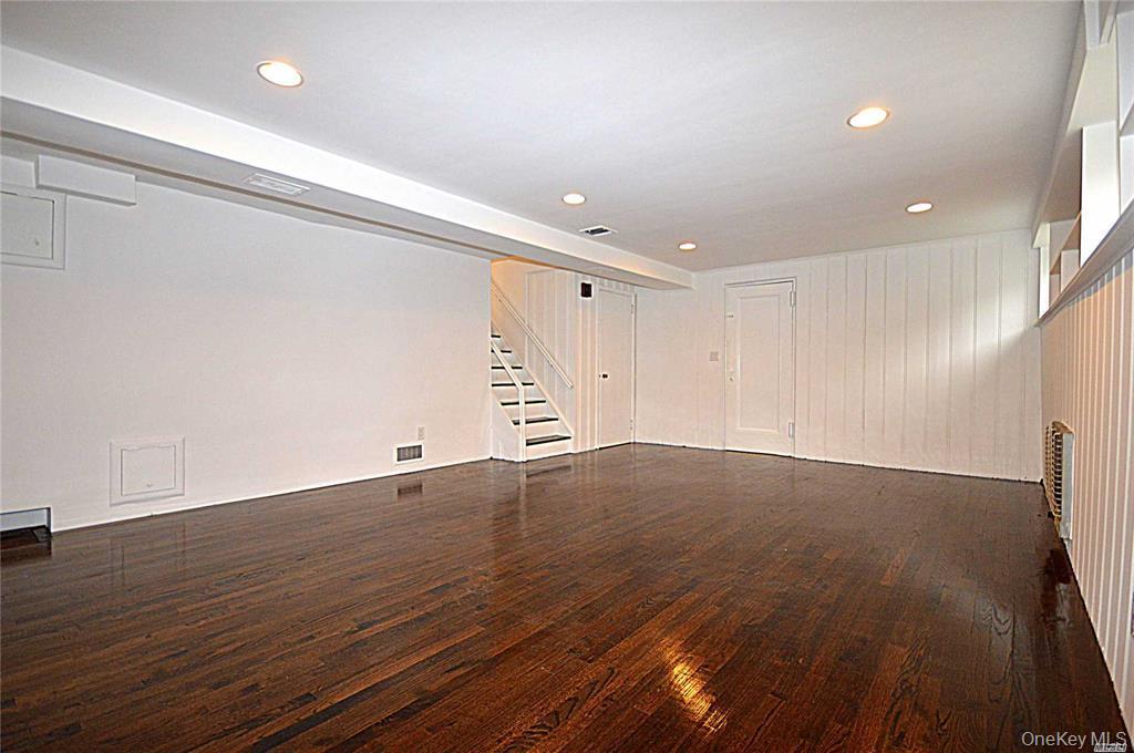 5 Gilbert Road Great Neck, NY 11024 - Photo 18 of 20 an empty room with wooden floor and windows