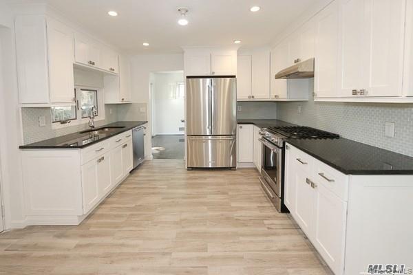 5 Gilbert Road Great Neck, NY 11024 - Photo 7 of 20 a kitchen with stainless steel appliances granite countertop a sink and a refrigerator