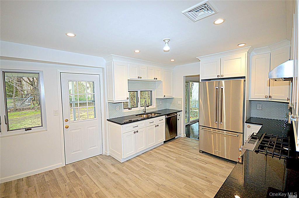 5 Gilbert Road Great Neck, NY 11024 - Photo 9 of 20 a kitchen with granite countertop stainless steel appliances a refrigerator cabinets and wooden floor